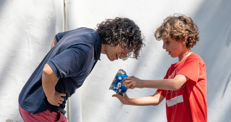 image of instructor and camper in red shirt looking at egg drop craft 